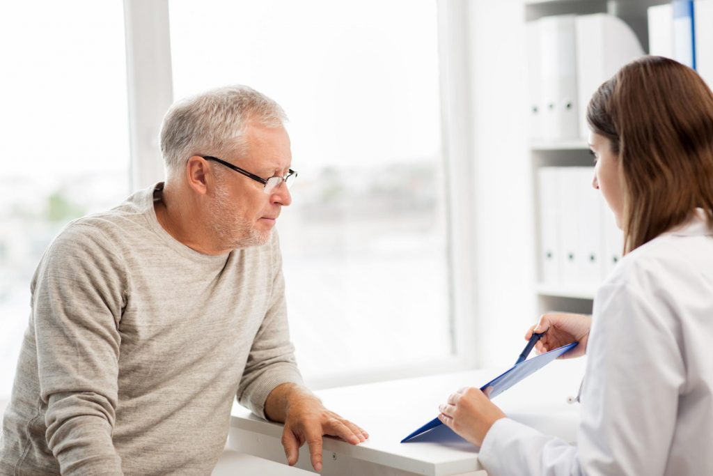 a doctor presenting the outline of a procedure to a male patient