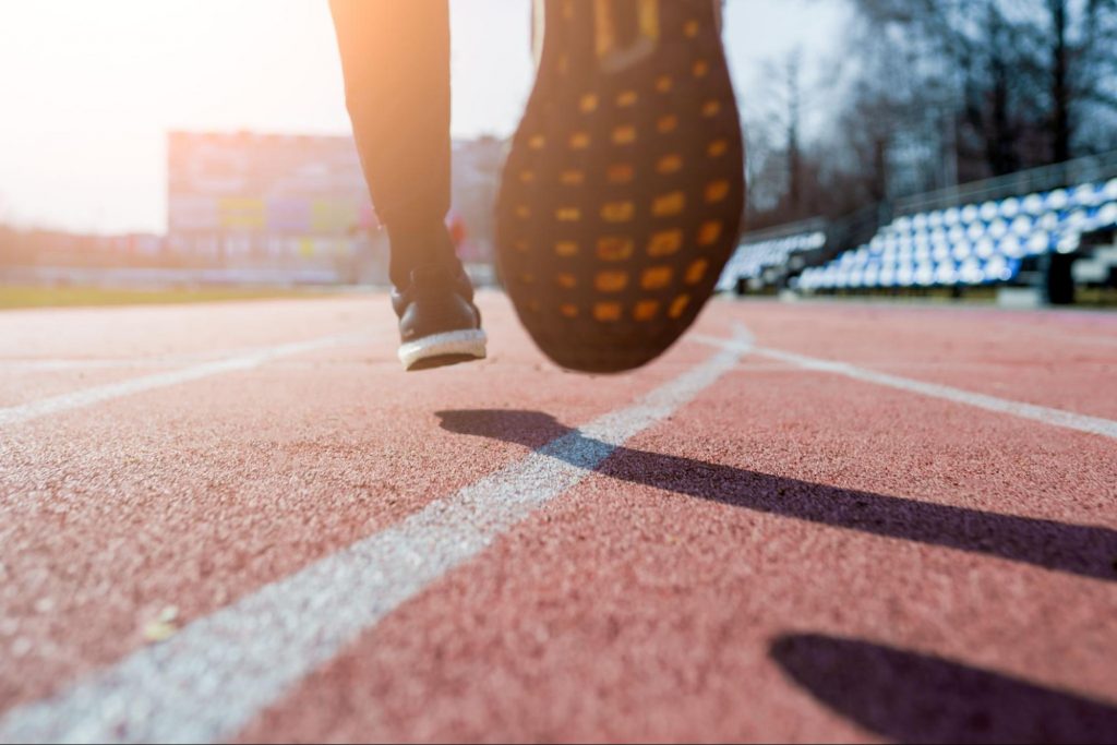 a close up of someone running on a track to represent activities that may impact your urologic health